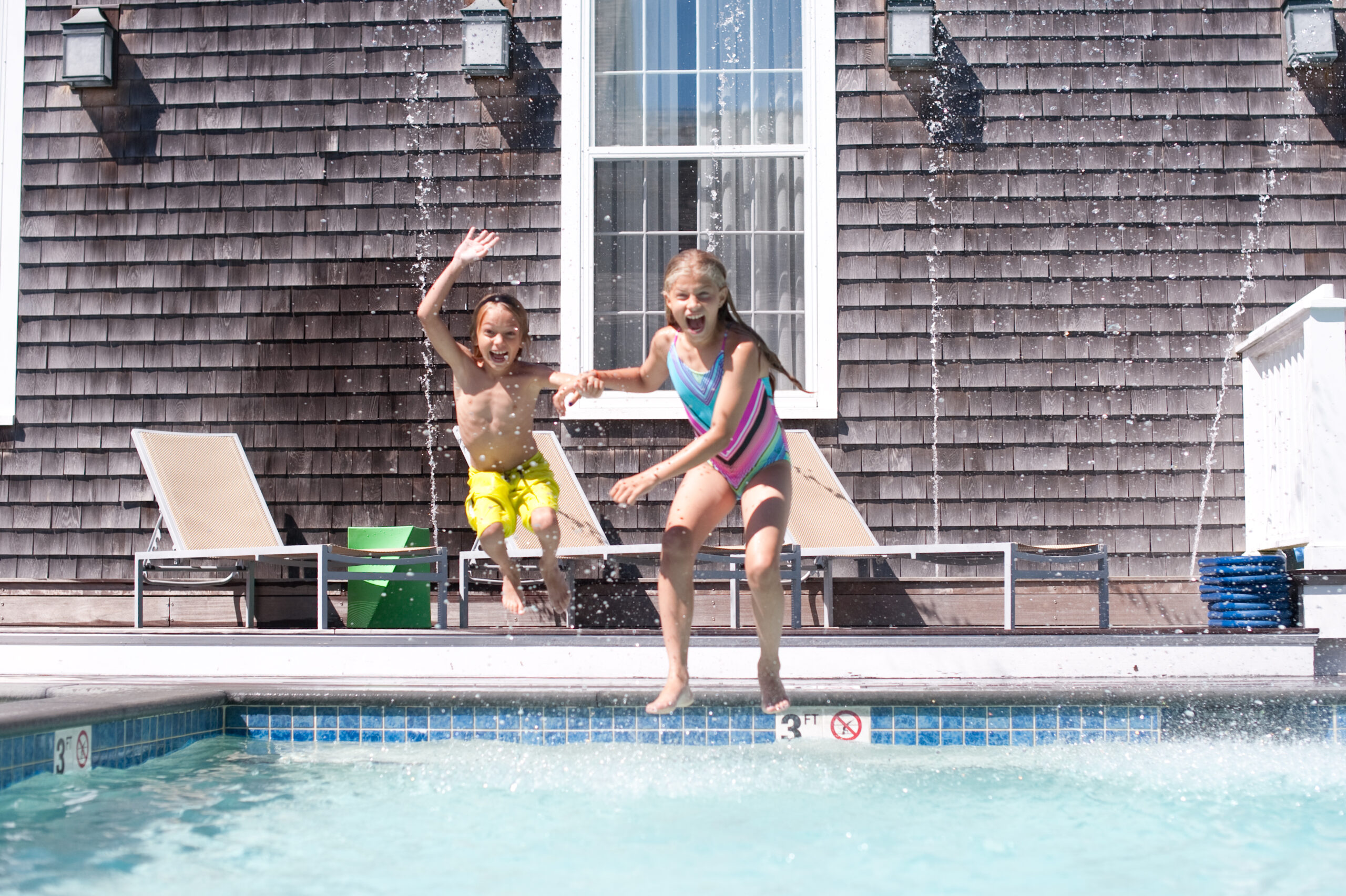 Kids jumping into a pool