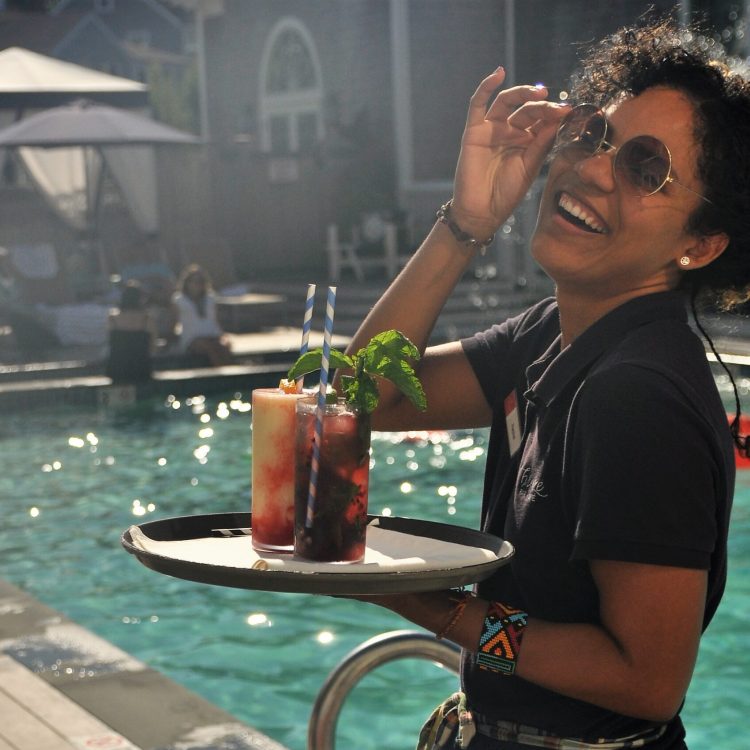 A woman holding a tray with drinks on it
