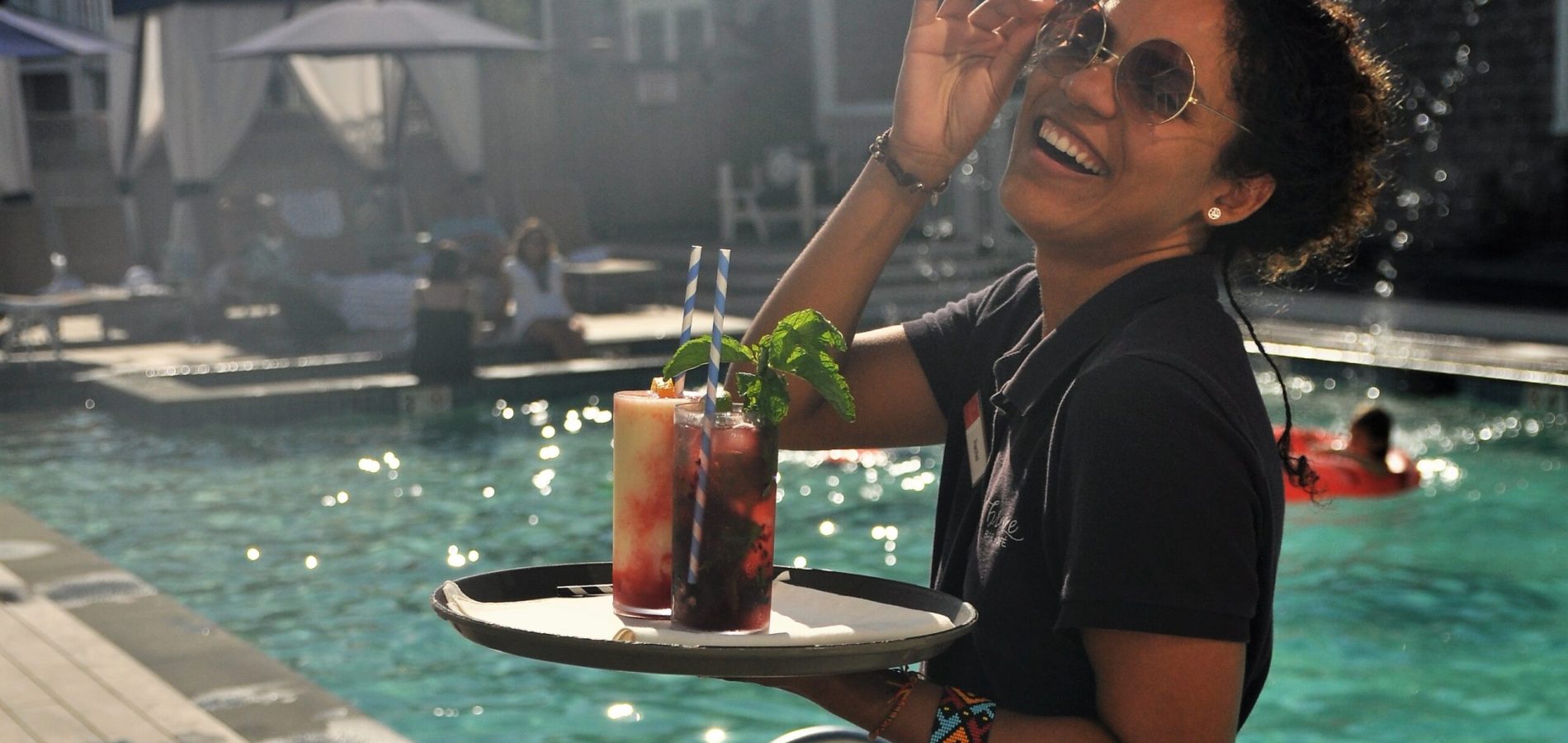 A woman holding a tray with drinks on it