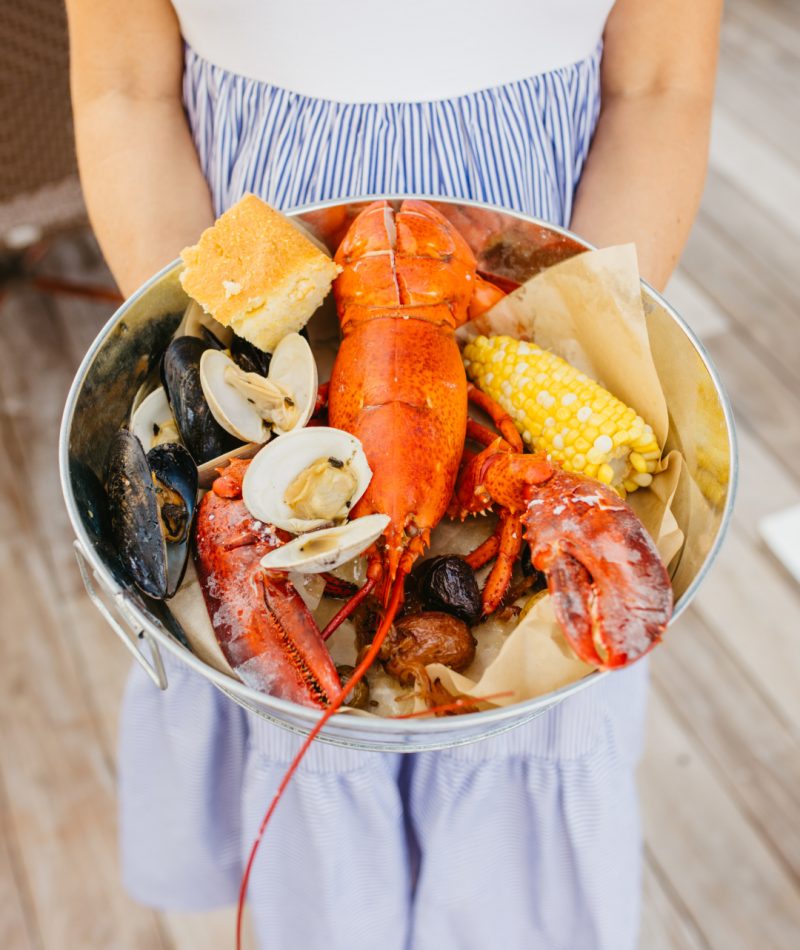 A woman holding a pot with seafood in it