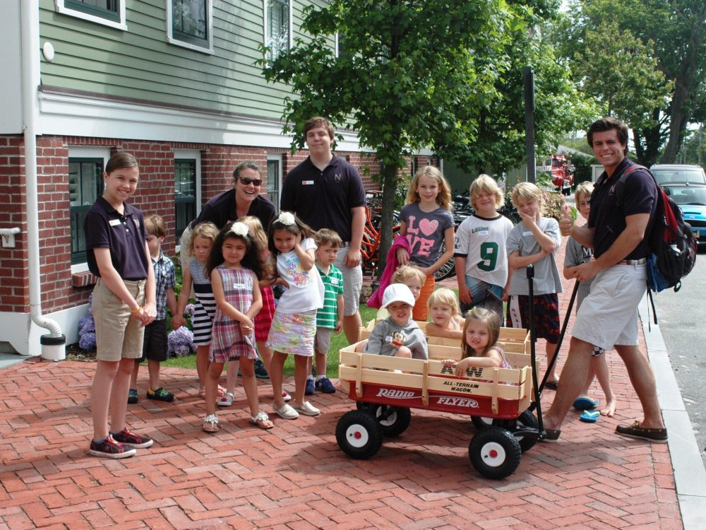 A group of people stand on a brick sidewalk